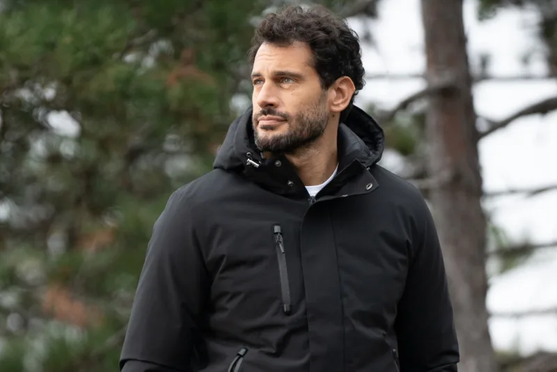 Uomo con giacca tecnica nera James Ross in un bosco
